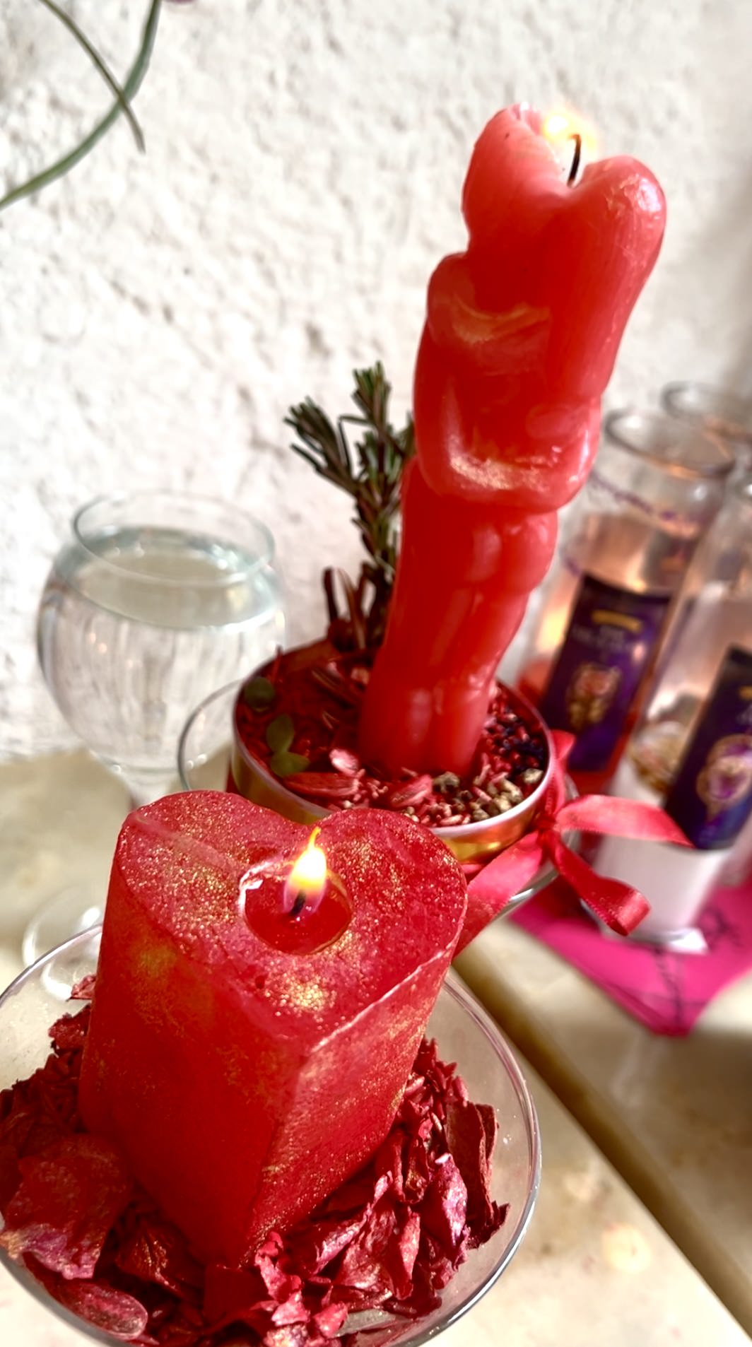 Dos velas, una en forma de corazón y otra en forma de pareja, para rituales mágicos.