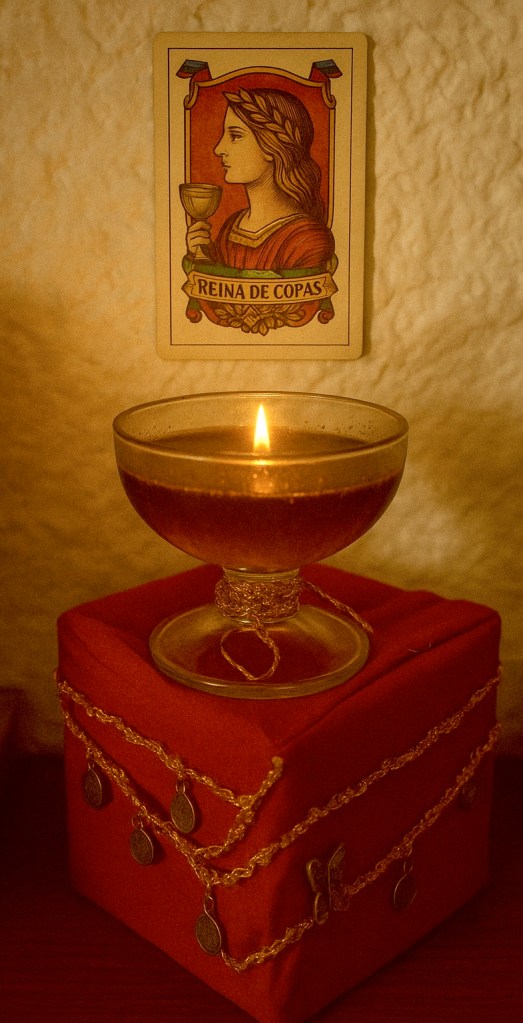Pañuelo rojo con monedas colgantes, copa con miel y carta de la baraja española.
